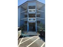 Three-story condominium building featuring blue siding, white railings, palm trees, and convenient parking at 9540 Shore Dr. # 1N, Myrtle Beach, SC 29572
