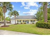 Charming one-story home with a welcoming porch and well-manicured lawn and tropical landscaping at 106 Willow Ridge Rd., Myrtle Beach, SC 29588