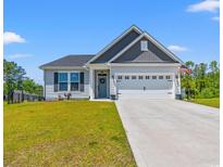 Charming single-Gathering home featuring well-manicured lawn, attached two car garage, and welcoming curb appeal at 127 Emerald Rush Ct., Longs, SC 29568