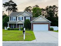 Charming two-story home with a well-manicured lawn, brick accents, and a two-car garage at 140 Zinnia Dr., Myrtle Beach, SC 29579