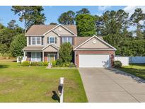 Charming two-story home with a manicured lawn and inviting curb appeal showcasing the traditional facade and attached garage at 140 Zinnia Dr., Myrtle Beach, SC 29579