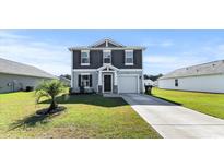 Charming two-story home boasts manicured lawn, attached garage, and classic architectural details at 153 Foxford Dr., Conway, SC 29526