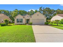 Charming single-story home with a well-manicured lawn, attached garage, and inviting curb appeal at 1617 Tradition Club Dr., Pawleys Island, SC 29585