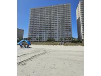 Large beachfront condo building with many balconies, ocean view, and tire tracks in the sand at 1625 S Ocean Blvd. # 106, North Myrtle Beach, SC 29582
