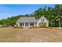 Charming home featuring a covered porch, manicured lawn, and tasteful landscaping, creating an inviting curb appeal at 1676 Elder Ln., Galivants Ferry, SC 29544