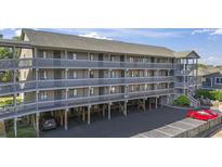 Exterior view of a multi-level condo building with wooden walkways and support beams over a parking area at 206 Maison Dr. # Q-204, Myrtle Beach, SC 29572
