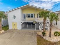Inviting two-story beach home with palm trees, white railings, and covered parking at 314 45Th Ave. N, North Myrtle Beach, SC 29582