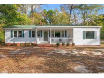 Charming single story home with white siding, green shutters, and a welcoming front porch at 3934 North Fraser St., Georgetown, SC 29440