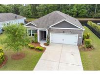 Charming single-story home featuring a brick facade, well-manicured lawn, and an attached two-car garage at 40 Parkside Dr., Pawleys Island, SC 29585