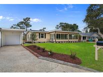 Charming single-story home featuring a manicured front yard and attached garage at 409 14Th Ave. S, North Myrtle Beach, SC 29582