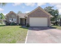 Charming brick home featuring a two-car garage and a well-maintained front yard with flowering plants at 4300 Cross Cut Trail, Myrtle Beach, SC 29579