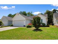Charming single-story home with a white exterior, two-car garage, and a beautifully landscaped front yard at 4591 Hidden Creek Ln., Myrtle Beach, SC 29579