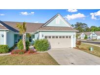 Charming, light-blue, one-story home with a two-car garage, complimented by lush landscaping at 5876 Cremona Dr., Myrtle Beach, SC 29577