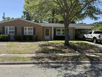 Charming single-story home features brick accents, mature trees, and an attached carport with a white pickup truck in the driveway at 617 Hibiscus Ave. # 617, Myrtle Beach, SC 29577