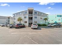 Three-story condo complex with ample parking, palm trees and outdoor stairwells at 6302 N Ocean Blvd. # G-3, North Myrtle Beach, SC 29582