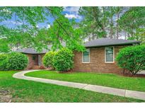 Charming brick home featuring a well-maintained lawn and a welcoming curved walkway at 8209 Timber Ridge Rd., Conway, SC 29526