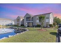 Beautiful condominium exterior featuring a serene pond and well-maintained landscaping at 8796 Cloister Dr. # B, Surfside Beach, SC 29575
