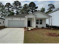 Charming single-story home featuring a spacious garage, welcoming front porch and manicured lawn at 1005 Laconic Dr., Myrtle Beach, SC 29588