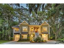 Charming two-story home with well-manicured landscaping and inviting front porch at 1033 Tuckers Rd., Pawleys Island, SC 29585