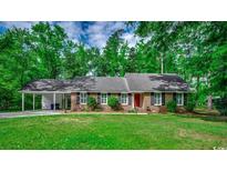 Charming brick ranch home with a well-manicured lawn and mature trees at 107 Azalea Dr., Conway, SC 29526