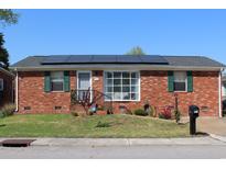 Charming brick home featuring solar panels, a well-maintained lawn and a pleasant front yard at 1145 Forest Dr., North Myrtle Beach, SC 29582