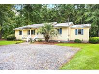 Charming single-story home with a gravel driveway, lush lawn and inviting front porch at 131 Oak Log Lake Rd., Conway, SC 29526