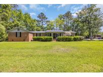 Charming single-story brick home with a well-manicured lawn and lush greenery in a serene neighborhood at 1907 Rose St., Conway, SC 29527