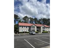 Exterior view of an apartment building with a red roof and balconies over parking spaces at 193 Charter Dr. # E3, Longs, SC 29568