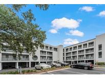 Condo building exterior with ample parking on a partly cloudy day at 201 N Hillside Dr. # 311-A, North Myrtle Beach, SC 29582