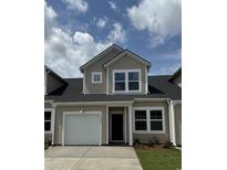 Charming townhome boasts a one-car garage and classic architectural details against a beautiful blue sky at 2086 Victory Way # 566, Myrtle Beach, SC 29579