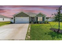 Charming single-story home featuring a well-manicured lawn, attached garage, and welcoming front entrance at 211 Seasons Trace Loop, Longs, SC 29568