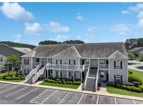 Inviting condo building with dual staircases, manicured landscaping, and ample parking at 217 Wando River Rd. # 12-H, Myrtle Beach, SC 29579