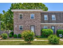 Charming brick townhome with well-maintained landscaping and cozy front entrance at 2701 Hillside Dr. S # 1, North Myrtle Beach, SC 29582