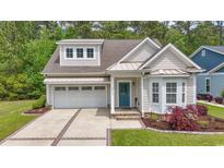Charming home featuring a manicured lawn, brick-lined driveway, and a welcoming blue front door at 2993 Moss Bridge Ln., Myrtle Beach, SC 29579