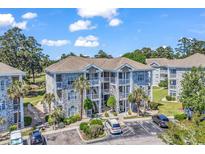 Beautiful condo with stone accents, white balconies, well-maintained landscaping and plenty of parking spaces at 4773 Wild Iris Dr. # 301, Myrtle Beach, SC 29577