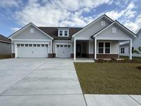 Charming single-Gathering home boasts a three-car garage and well-maintained front yard at 543 Oak Landing Dr., Myrtle Beach, SC 29588