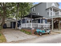 Charming beach home featuring a welcoming porch area and a convenient golf cart for easy transportation at 6001- 1771 S Kings Highway, Myrtle Beach, SC 29575