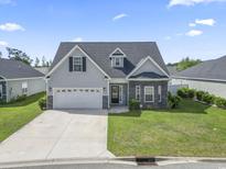 Charming home with a well-manicured lawn, two-car garage, and inviting front entrance under a bright blue sky at 712 Hobonny Loop, Longs, SC 29568