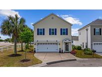 Charming two-story home featuring blue shutters, attached two-car garage, and beautifully landscaped front yard at 903 Ocean Pines Ct., North Myrtle Beach, SC 29582