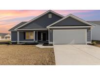 Charming single-Gathering home features gray siding, attached garage and well-manicured lawn at 1013 Woodside Dr., Conway, SC 29526