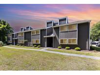 Two-story condo complex featuring a modern exterior, well-maintained landscaping, and inviting walkways on a sunny day at 10301 North Kings Hwy. # 13-5, Myrtle Beach, SC 29572