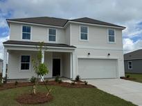Charming two-story home with a manicured lawn and a two-car garage, offering classic curb appeal at 1038 Laconic Dr., Myrtle Beach, SC 29588
