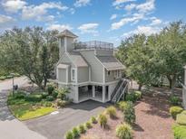Beautiful coastal home featuring elevated construction, a tower, roof deck, and meticulously landscaped grounds at 1608 Harbor Dr., North Myrtle Beach, SC 29582