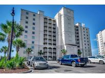 Multi-story condominium with a white facade, multiple balconies, and lush landscaping surrounded by a clear, blue sky at 2151 Bridge View Ct. # 2-803, North Myrtle Beach, SC 29582