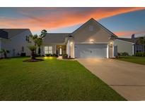 Charming single Gathering home featuring a well maintained lawn, an attached two car garage, and a welcoming front entrance at 2446 Craven Dr., Myrtle Beach, SC 29572