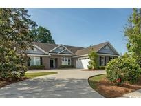 Charming brick home featuring a wide driveway, attached garage, and well-manicured landscaping at 2600 Henagan Ln., Myrtle Beach, SC 29588
