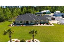Stunning aerial view of custom home with lush lawn, professional landscaping and mature trees at 2767 Lees Landing Circle, Conway, SC 29526