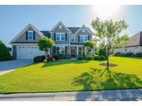 Charming two-story home with a well-manicured lawn, lush landscaping, and a welcoming front entrance at 304 San Martin Ct., Longs, SC 29568