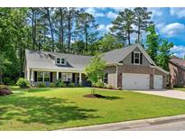 Charming single-Gathering home with brick accents, well-manicured lawn, and two-car garage at 370 Foxtail Dr., Longs, SC 29568