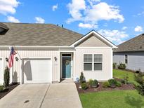 Charming single-story home with a blue front door, attached garage, manicured lawn, and lovely landscaping at 3766 Bells Lake Circle # 3766, Longs, SC 29568